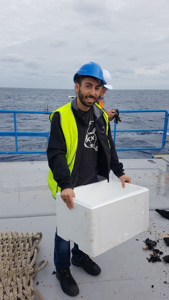 Jeremy collecting samples on deck and storing them in ice to transfer them to his lab.