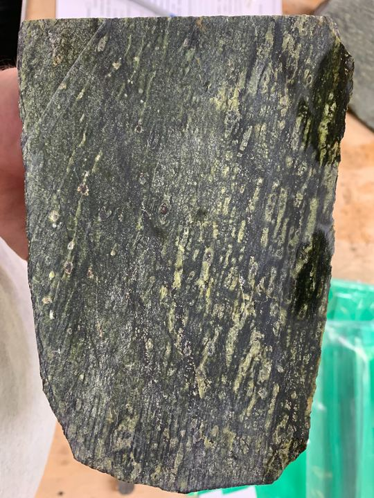 Image 3. Serpentinite, probably a rock from the base of the oceanic crust as it transitions to the upper mantle. The foliation, or layers, are caused as the minerals get squashed under pressure  Image: Jamie Menzies. 