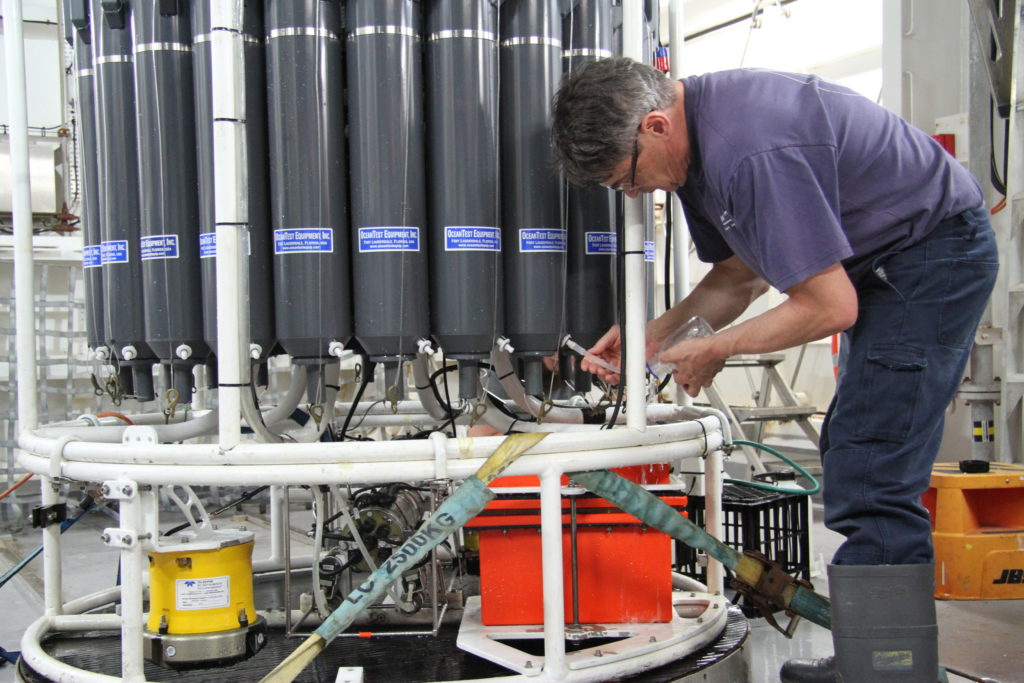 Caption: Peter Hughes, CSRIO MNF Hydrochemist taking water samples from the CTD.