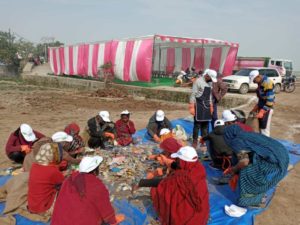 Group of people in India sorting plastic on a mat