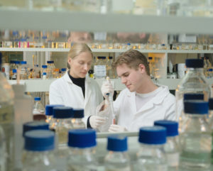 Two people in white lab coats working in a scientific laboratory