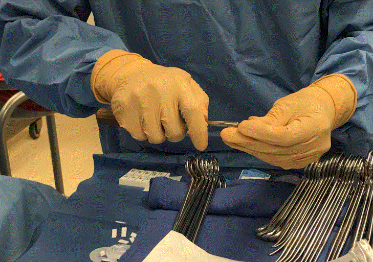 surgeon's gloved hands in operating theatre