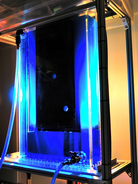 Large sheet of metal in a glass tank filled with blue coloured solution