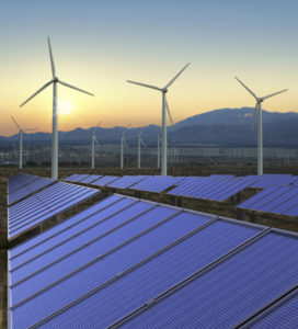 Solar panels and wind turbines during sunrise