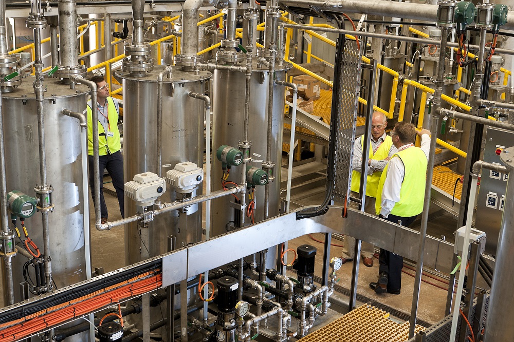 Three people in hi-vis working in industrial processing plant