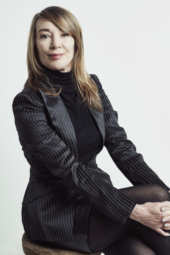 A woman in a dark suit smiling at camera