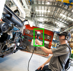 An operator scanning the engine of a vehicle using the HeatWave device.