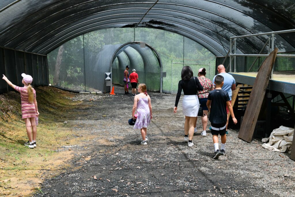 Visitors walk through a shade cloth tunnel
