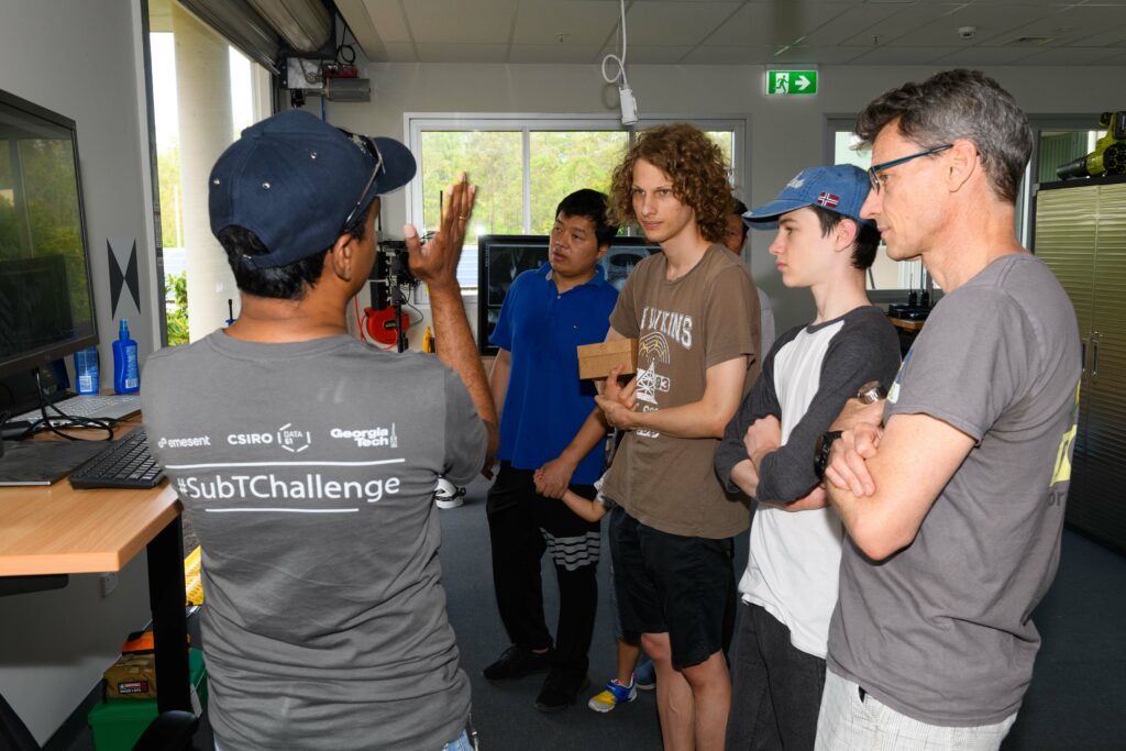 A staff member explains something to a group of visitors