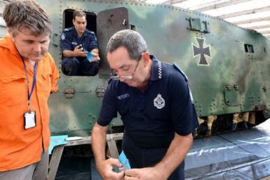 TCOLD CASE: Police Ballistics Services officer Alan Piper (right) shows a mould taken from the First World War German tank Mephisto to Queensland Museum senior curator Michael Westaway. Police officer Ashley Huth is in the tank with another mould.