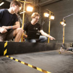 6 legged robot learning to walk, while researchers observe its walking pattern
