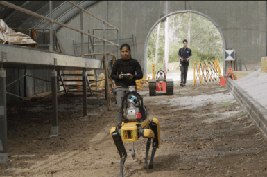 Two researchers walk into a tunnel with some ground robots
