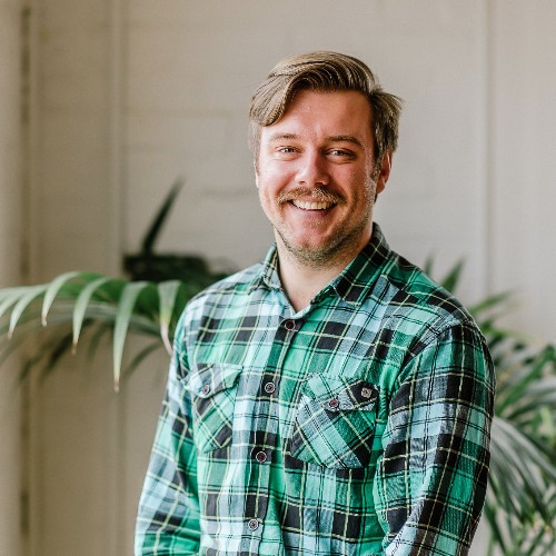 Head shot of Tim Leeson in a green check shirt