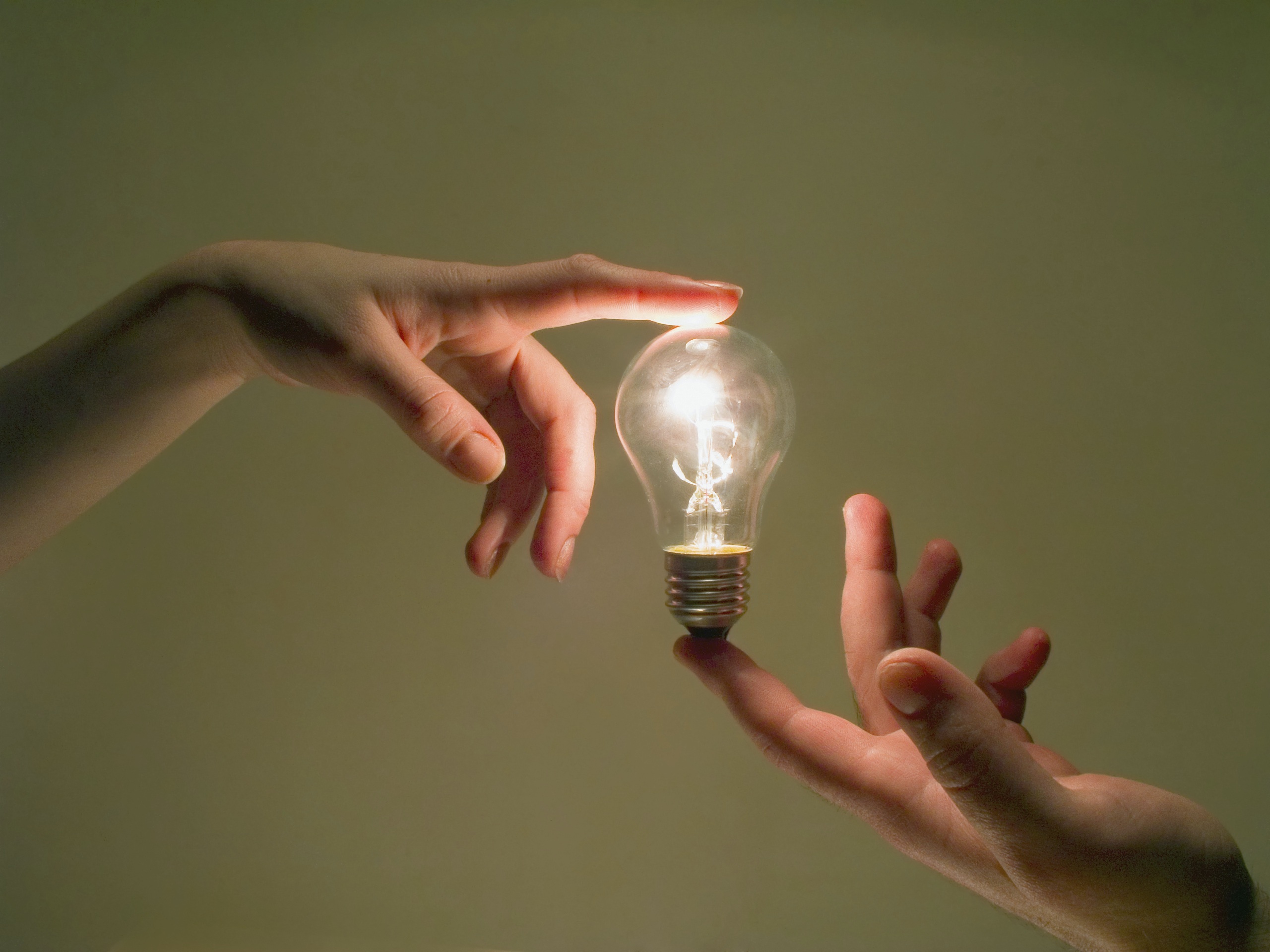 Lightbulb held between the index fingers of two hands