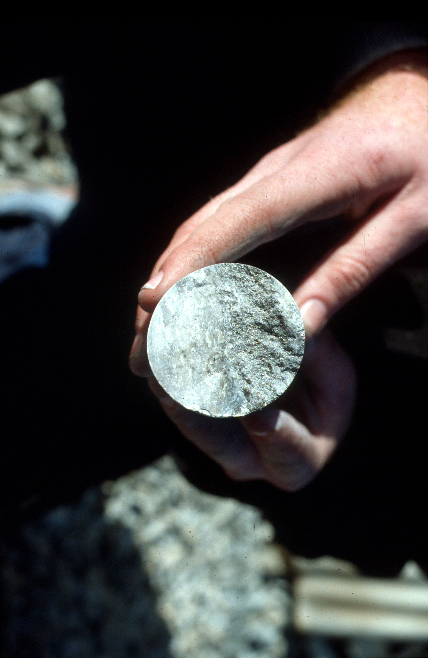 Mine core sample cross section held in a hand