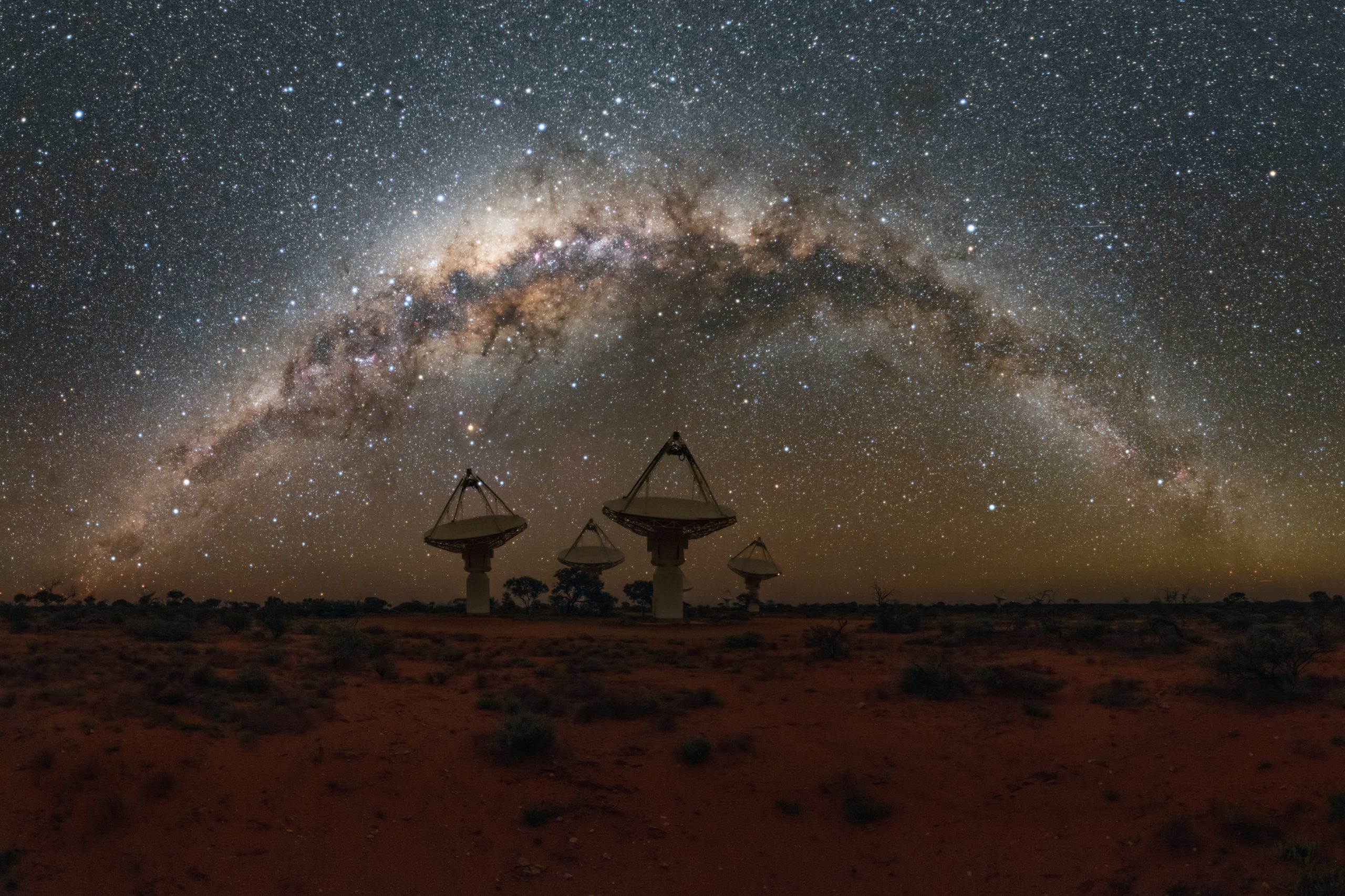 Radio telescope antennas in the desert beneath the Milky Way
