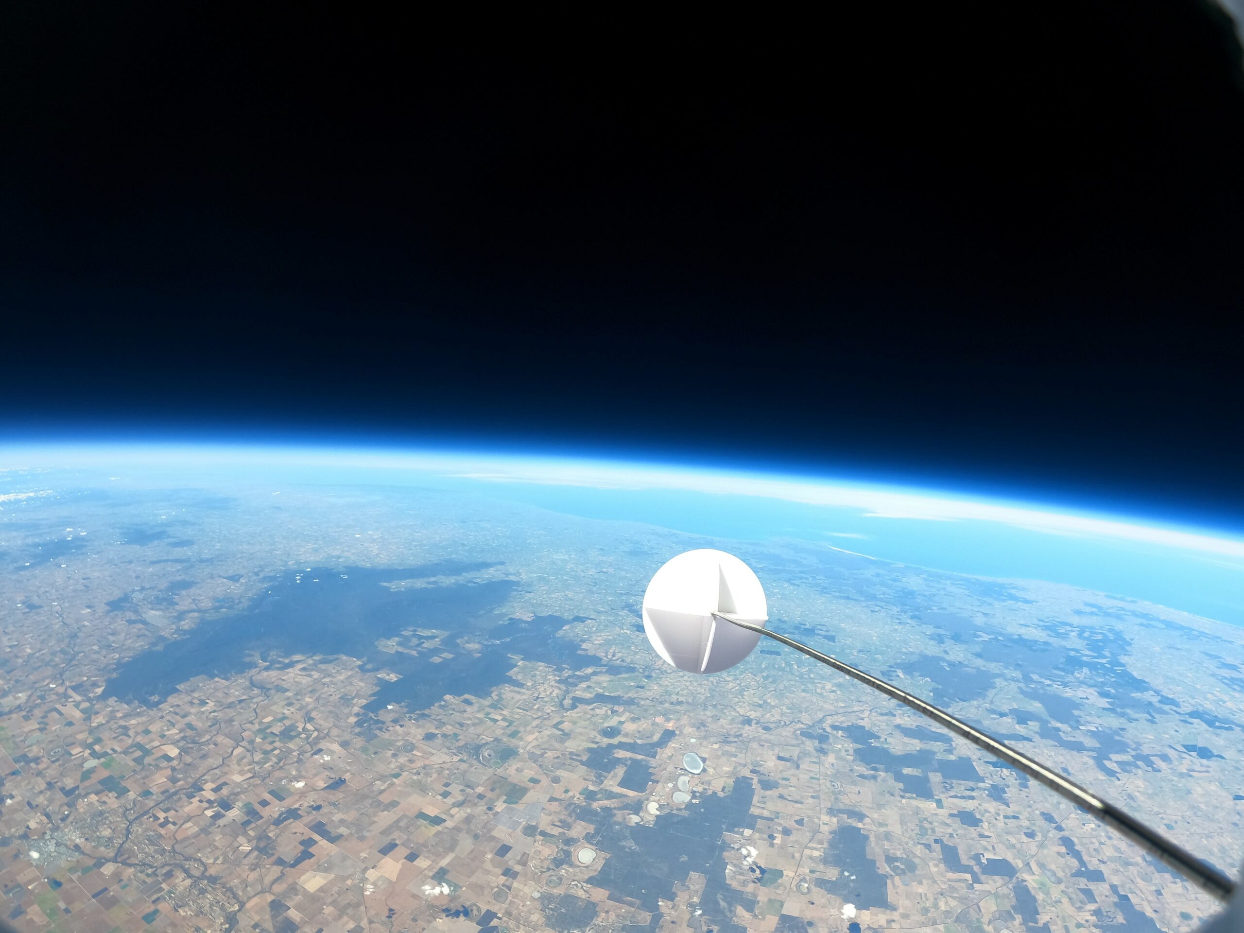 Stratospheric balloon in space with earth horizon in the background
